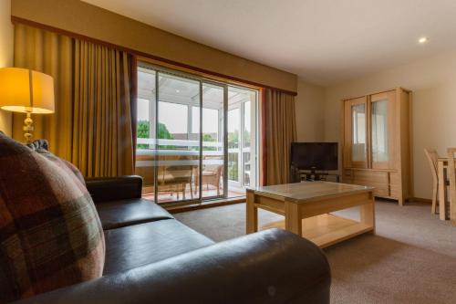 a living room with a couch and a table at Macdonald Spey Valley Resort in Aviemore