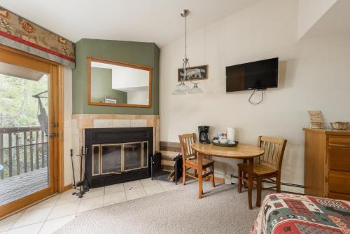 a living room with a table and a fireplace at Ponderosa Lodge in Estes Park