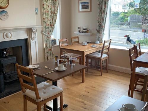a dining room with a table and chairs and a fireplace at Holly Trees in Seahouses