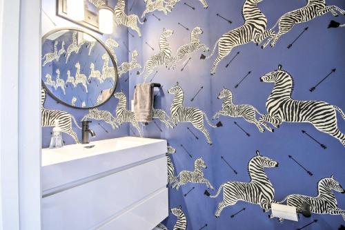 a bathroom with a zebra mural on a blue wall at 2 Mi to National Mall Modern DC Retreat with Patio in Washington