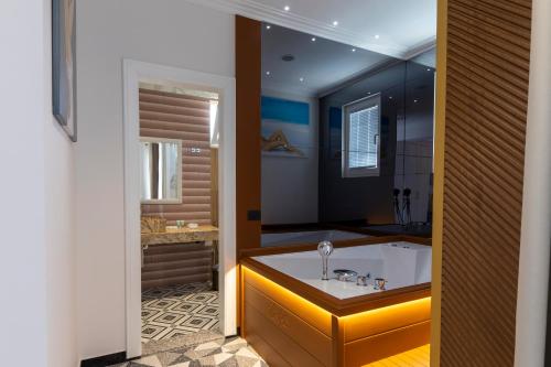 a bathroom with a bath tub with a sink at NOLEA Boutique Hotel in Velipojë