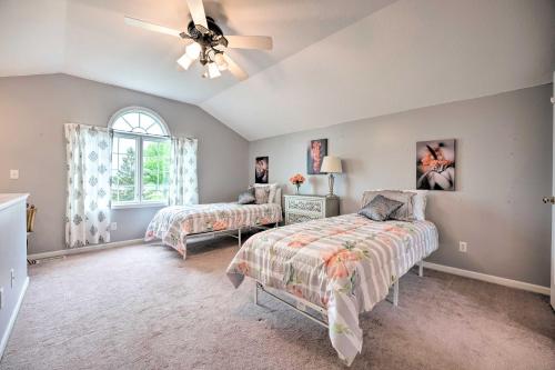 une chambre avec deux lits et un ventilateur de plafond dans l'établissement Furnished Deck and Playset Irish Hills Farmhouse!, à Tipton