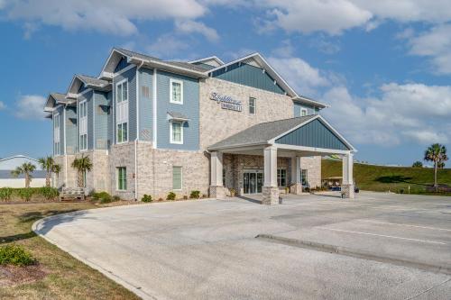 a large house with a driveway in front of it at Lighthouse Suites - Best Western Signature Collection in Emerald Isle