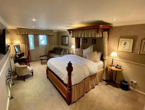 a bedroom with a large bed and a living room at Holdsworth House Hotel in Halifax