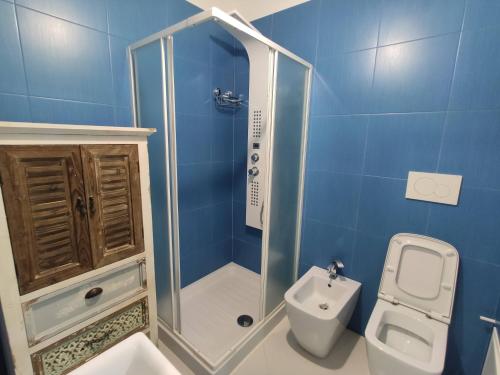 y baño azul con ducha y aseo. en Ulivi di Minerva - Boutique Holiday Home - Apartment ZEUS - Ostuni - Fasano - Cisternino, en Montalbano