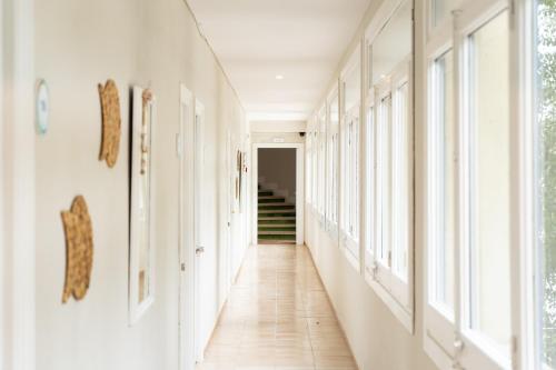 a hallway with white walls and windows at Hotel Aubí in Sant Antoni de Calonge