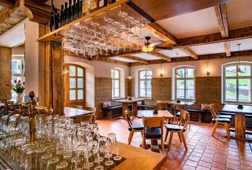 una habitación con mesas, sillas y copas de vino en Hotel KORTUS en Jetřichovice