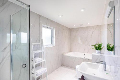a white bathroom with a shower and a sink at The Vale Golf & Country Club in Bishampton