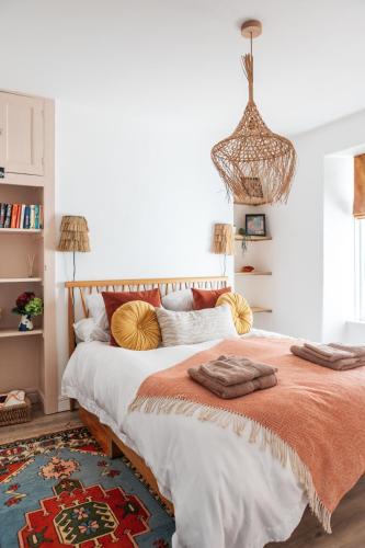 a bedroom with a large bed with an orange blanket at Stunning views over the beautiful Falmouth Harbour in Falmouth