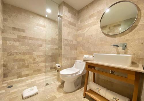 a bathroom with a toilet and a sink and a mirror at Hotel MX condesa in Mexico City