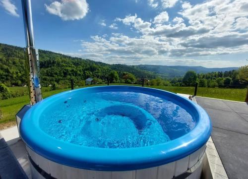 a hot tub on a patio with a view at Apartamenty 'Okno z widokiem' in Wisła