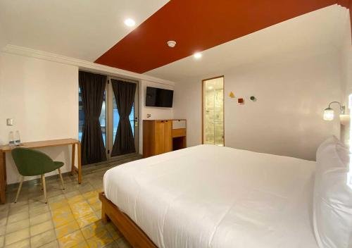 a bedroom with a large white bed and a desk at Hotel MX condesa in Mexico City