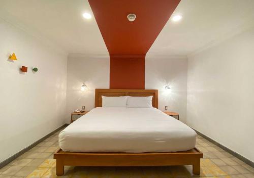 a bedroom with a large bed with white sheets at Hotel MX condesa in Mexico City