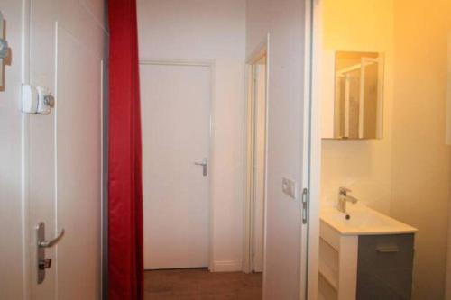 La salle de bains est pourvue d'un lavabo et d'une porte blanche. dans l'établissement Centre mer, à Saint-Valery-en-Caux