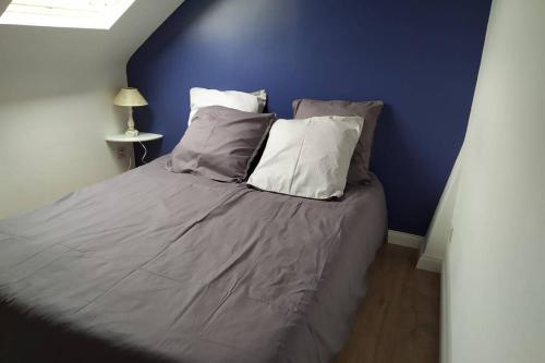 un lit dans une chambre avec un mur bleu dans l'établissement Centre mer, à Saint-Valery-en-Caux