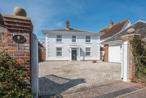a white house with a gate and a driveway at The Grange, Aldeburgh in Aldeburgh