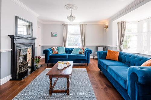 a living room with blue couches and a coffee table at The Grange, Aldeburgh in Aldeburgh