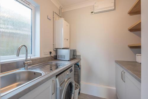 a kitchen with a sink and a washing machine at The Grange, Aldeburgh in Aldeburgh