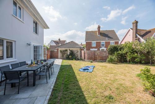 a patio with a table and chairs in a yard at The Grange, Aldeburgh in Aldeburgh