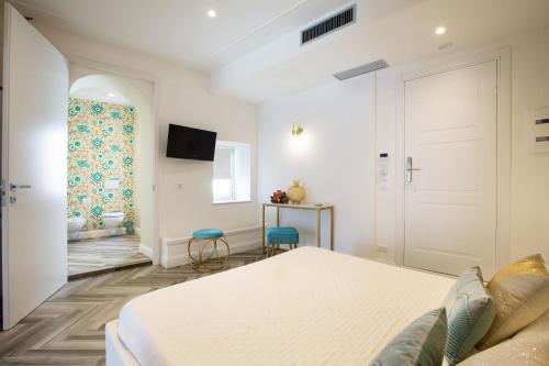 a white bedroom with a bed and a door at La Terrazza Antica Dimora in Campobasso