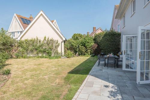 a patio with a table and chairs in a yard at The Grange, Aldeburgh in Aldeburgh