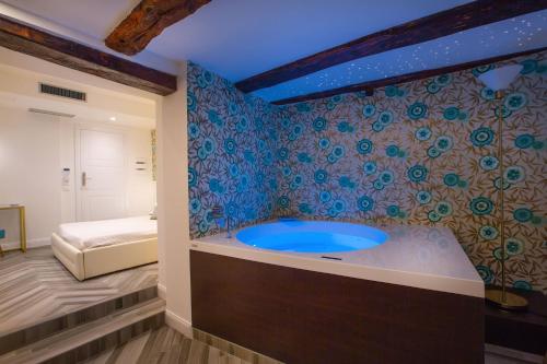 a bathroom with a blue tub in a room at La Terrazza Antica Dimora in Campobasso