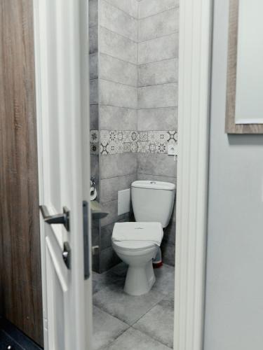 a bathroom with a white toilet in a room at готель Тячів in Tyachiv