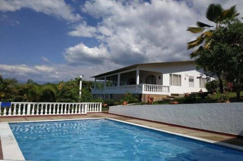 a house with a swimming pool in front of a house at Casa de campo con hermosa vista in Anapoima