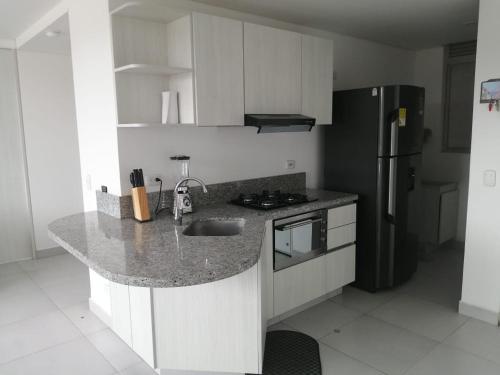 a kitchen with a sink and a refrigerator at Velas Al Mar - Apartamento Rodadero Gaira in Gaira