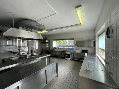 a large kitchen with stainless steel appliances and a counter at K 357 - Low budget Hotel in Ratekau bei Lübeck in Ratekau
