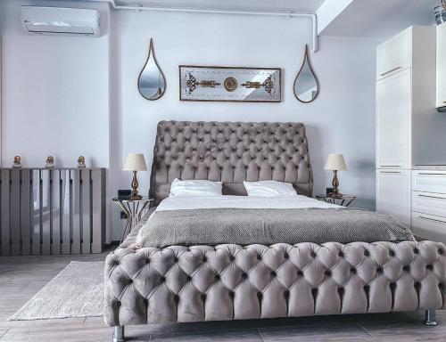 a bed with a tufted headboard in a bedroom at Mamaia Luxury Studio Apartment T in Mamaia