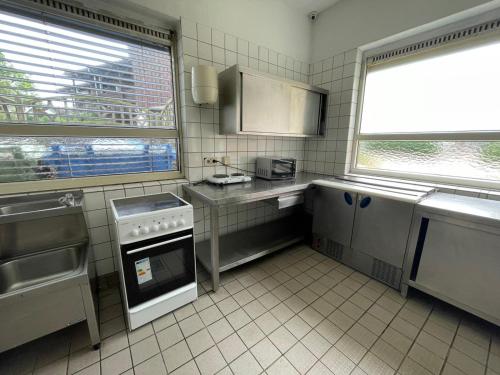 a kitchen with a sink and a stove at K 357 - Low budget Hotel in Ratekau bei Lübeck in Ratekau
