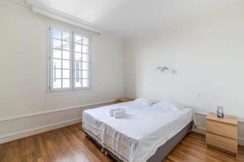une chambre blanche avec un lit et une fenêtre dans l'établissement Appartement Albâtre - Welkeys, à Lyon
