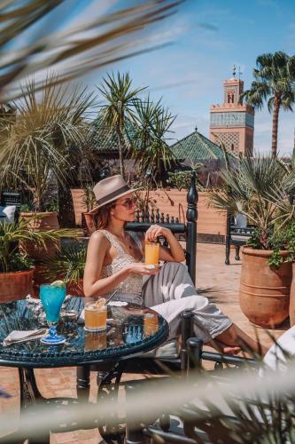 a woman sitting at a table playing a trumpet at La Sultana Marrakech in Marrakesh
