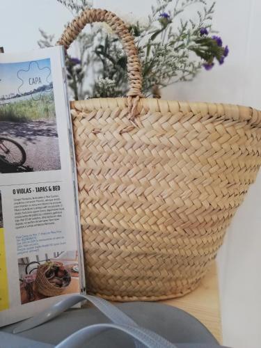 a basket sitting on a table next to a book at O VIOLAS - Art Coffee & Guesthouse in Praia de Mira