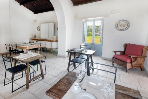 a dining room with a table and chairs and a couch at Masseria Berzario in Melendugno