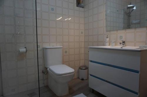 łazienka z toaletą, umywalką i lustrem w obiekcie CASA DA MADRIÑA w mieście Cambados