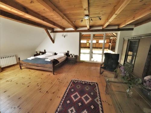 a large bedroom with a bed and a wooden ceiling at Pod Lipami in Zawady