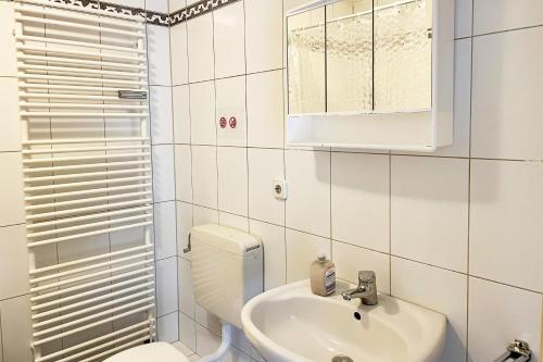 a white bathroom with a toilet and a sink at Schöne 3 Zimmerwohnung in Düren in Düren - Eifel