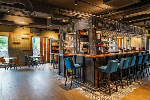 a bar with blue chairs at a restaurant at B&B HOTEL Clermont-Ferrand A71-A75 La Méridienne in Clermont-Ferrand