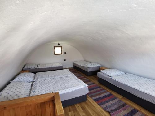 una camera con tre letti in una stanza con soffitto di Zuzka a Ižipovce