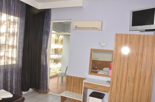 Una sala de estar con televisión y un espejo. en Resitalya Hotel, en Alanya