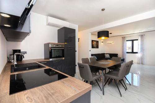 a kitchen and dining room with a table and chairs at Apartments Villa Casia in Srima
