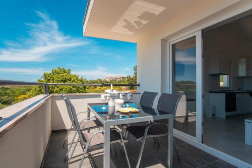 a table and chairs on a balcony with a view at LUNA Residence in Novalja