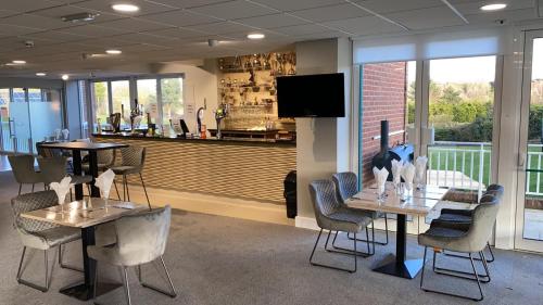 a restaurant with two tables and chairs and a bar at The Vale Golf & Country Club in Bishampton