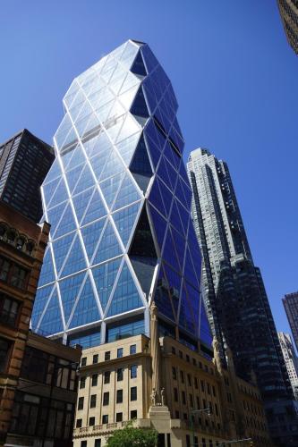 a tall glass building in a city with buildings at Nap York Central Park Sleep Station in New York