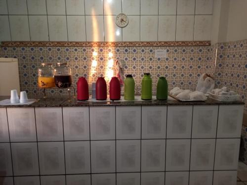 a kitchen counter with different colored bottles on it at Hotel Marabá in Jundiaí