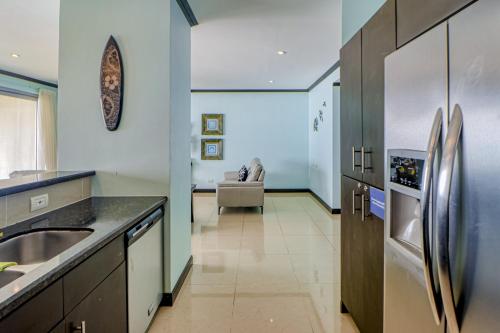 a kitchen with stainless steel appliances and a living room at Diamante del Sol 602N in Jacó
