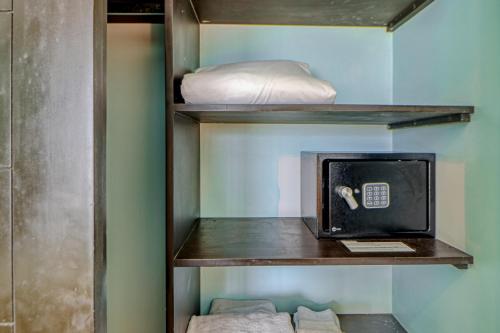 a room with a shelf with a microwave and a bed at Diamante del Sol 602N in Jacó