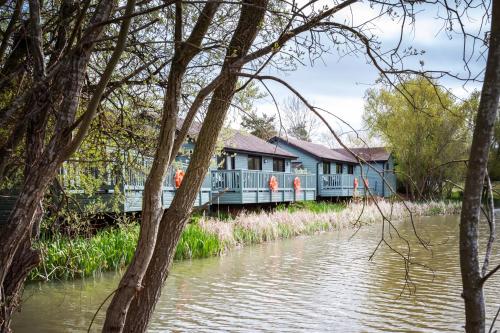 a house on the side of a river at The Vale Golf & Country Club in Bishampton
